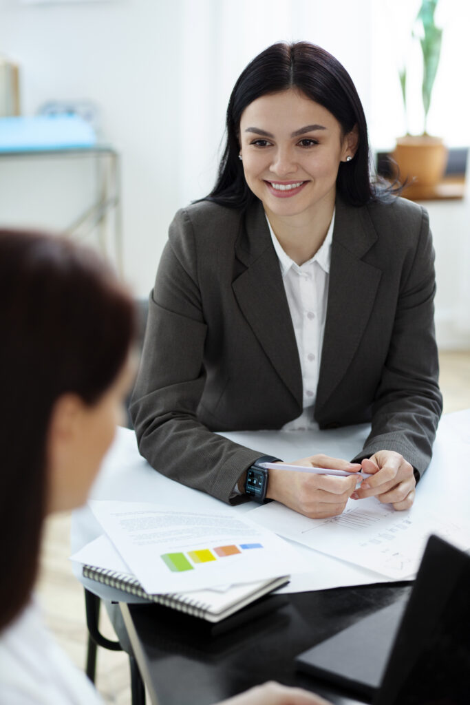 Deux femmes souriantes discutant pendant un entretien de recrutement, illustrant la réussite d’une candidature avec un CV adapté aux standards français